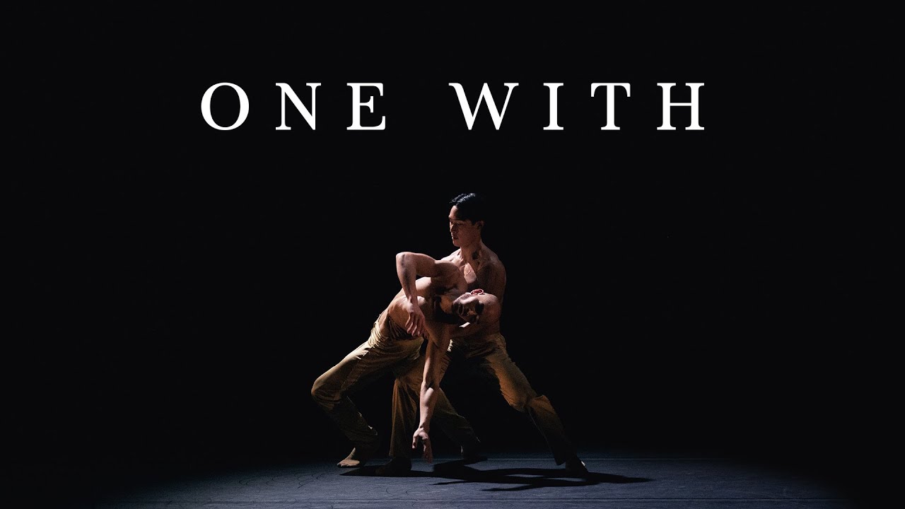 Ballet Kelowna dancers perform under theatrical light and haze.