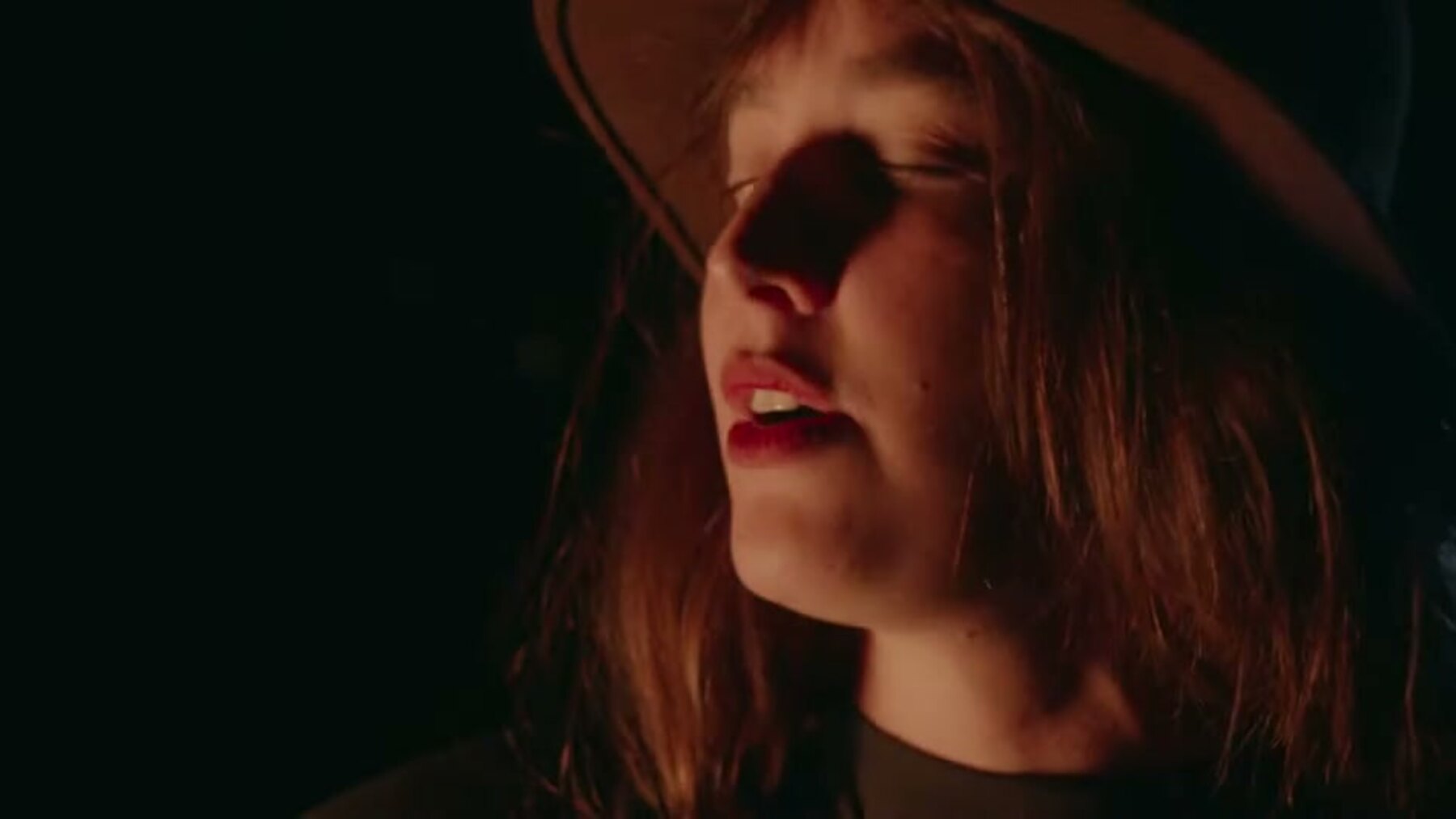 Sarah Osborne performs in a dark, warm-lit portrait from Autumn Sun.