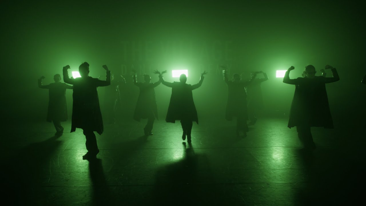 The Sockeye 2025 ensemble performs in green backlight and haze.